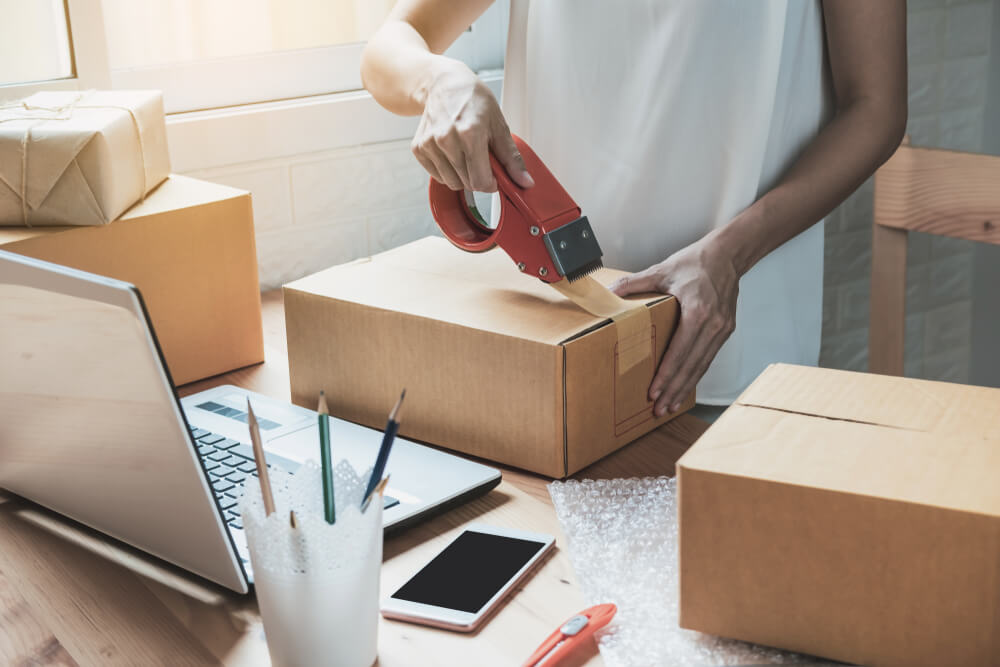 young woman packaging ecommerce product for safe shipping